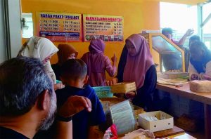 Wisatawan sedang membeli  Tahu Aci Kamoci di Gerai Taman Anggrek  jalan Raya tuwel – Guci Kabupaten Tegal Wisatawan sedang membeli  Tahu Aci Kamoci di Gerai Taman Anggrek  jalan Raya tuwel – Guci Kabupaten Tegal