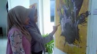 Pengunjung melihat karya Djentot Subechi yang memamerkan 29 lukisan abstrak di Space Art Lantai 3 Perpustakaan Umum Kabupaten Purbalingga, 2-23 Desember 2023. Foto: Mahendra Yudhi Krisnha | tabloidelemen.com