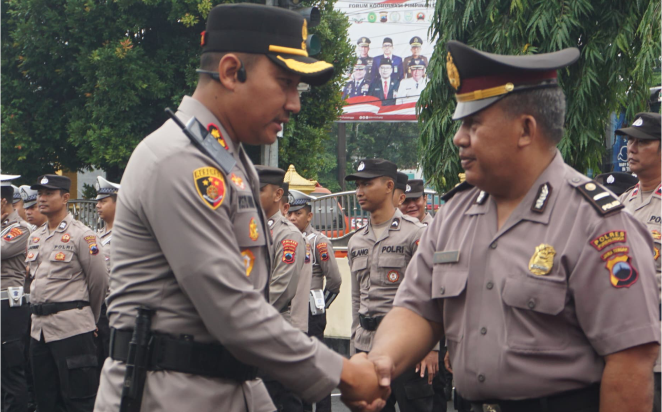 Kapolres Purbalingga, AKBP Rosyid Hartanto bersalaman dengan Ajun Inspektur Polisi Satu (Aiptu) Nuryanto Kanit Binmas Polsek Bukateja usai menerima kenaikan pangkat pengabdian menjadi Inspektur Polisi Dua (Ipda) di halaman Mapolres Purbalingga, Senin 02 Desember 2024.