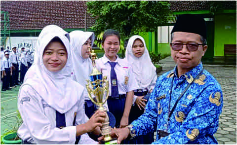 Kepala SMP Negeri 2 Purbalingga, Soderi saat menyerahkan piala dan penghargaan kepada para siswa berprestasi. Sumber Foto: smpn2purbalingga.sch.id Kepala SMP Negeri 2 Purbalingga, Soderi saat menyerahkan piala dan penghargaan kepada para siswa berprestasi. Sumber Foto: smpn2purbalingga.sch.id