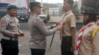 Ketua Majelis Pembimbing Satuan Karya Pramuka Bhayangkara (Mabi Sakahayangkara) Kwartir Cabang Kabupaten Purbalingga, Kak AKBP Achmad Akbar menyematkan nametag kegiatan, usai Apel Pemberangkatan Pengukuhan Pramuka Saka Bhayangkara Angkatan 37 Tahun 2025.