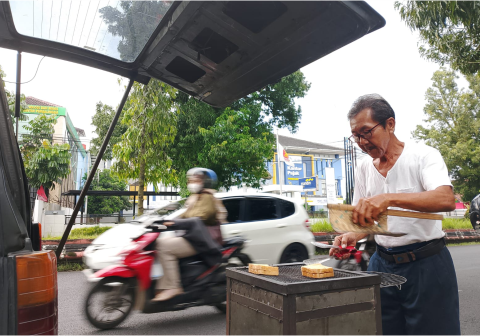 Markus Widianto sedang meracik roti bakar menggunakan arang, sebuah kenangan melalui kepulan asap tipis yang membawa aroma gandum terbakar.