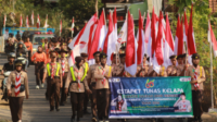 Iring-iringan pasukan Estafet Tunas Kelapa Kwarda Jateng dari Kwarcab Banjarnegara bergerak melintasi jalur utama dengan pengawalan ketat dari 61 anggota pramuka penggalang dan penegak pilihan.